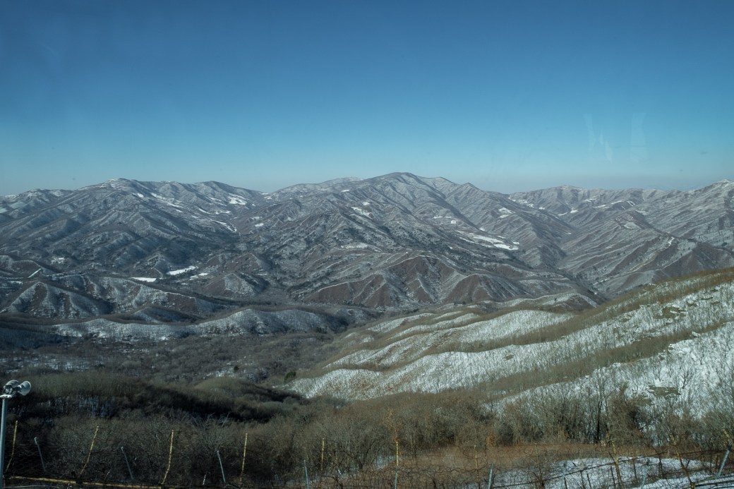 20170201-7782 A view into North Korea, through terrible tinted glass and trying to avoid a soldier shouting at me for taking photos when I wasn't alllowed to. From the DMZ observatory